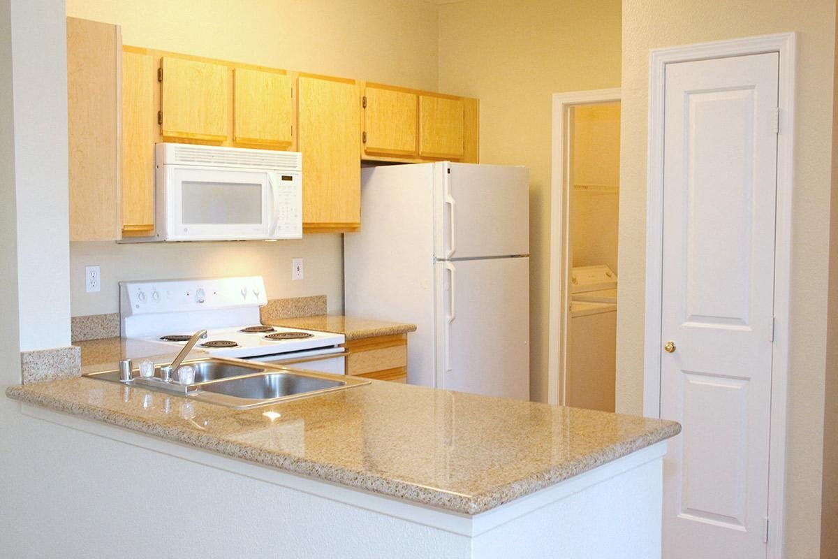 a kitchen with white appliances and a granite counter top