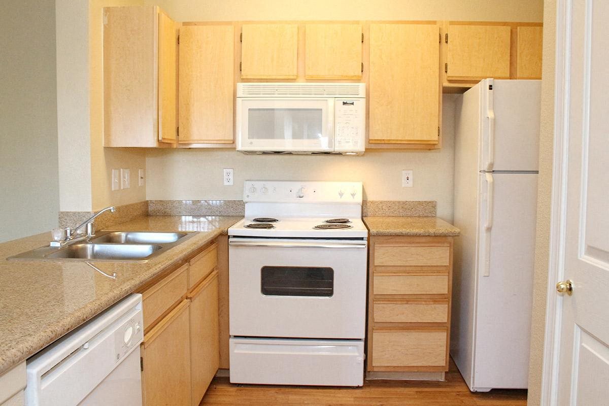 a kitchen with white appliances and wooden cabinets