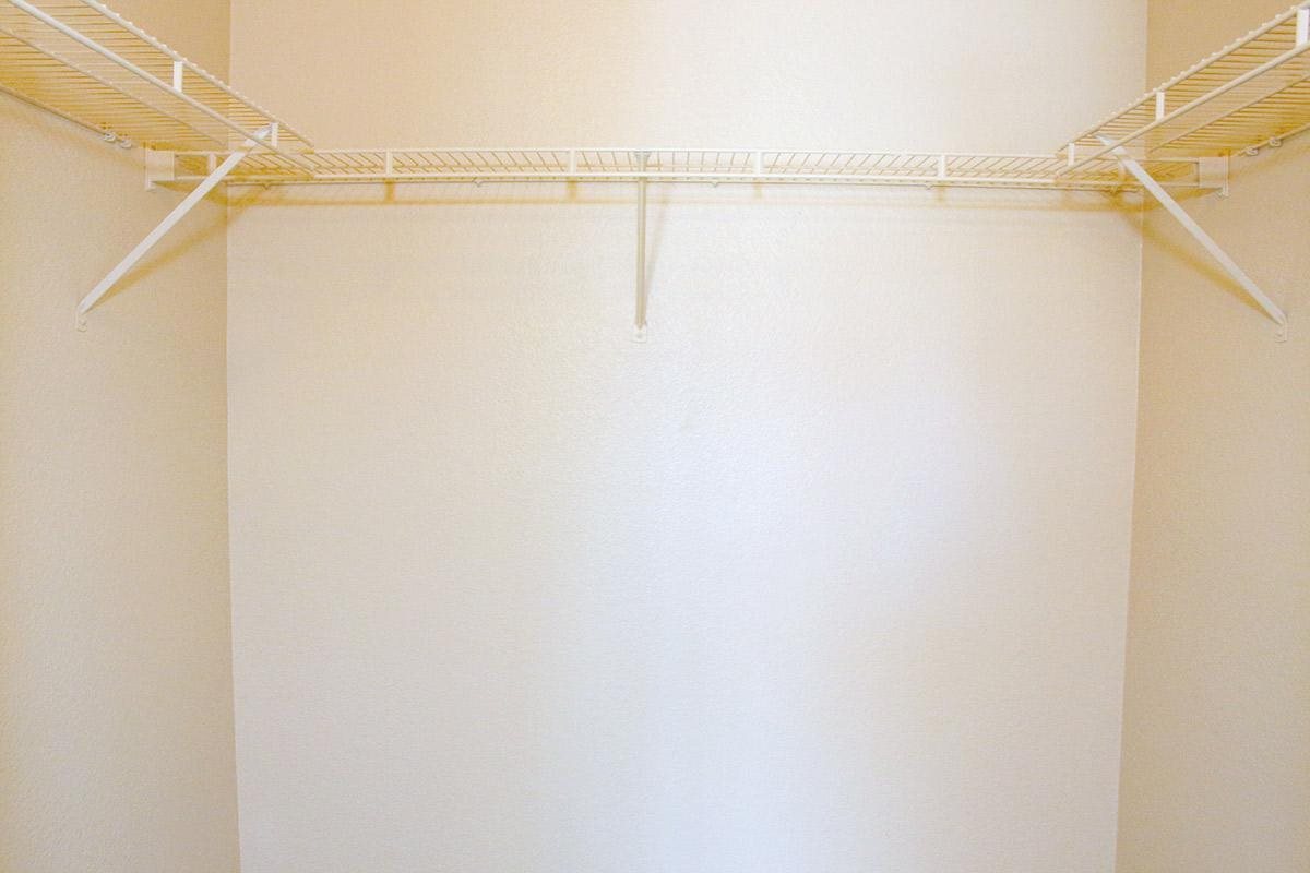 an empty closet with a white shower curtain and a wire rack