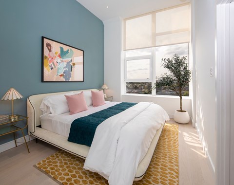 a bedroom with a bed and a large window