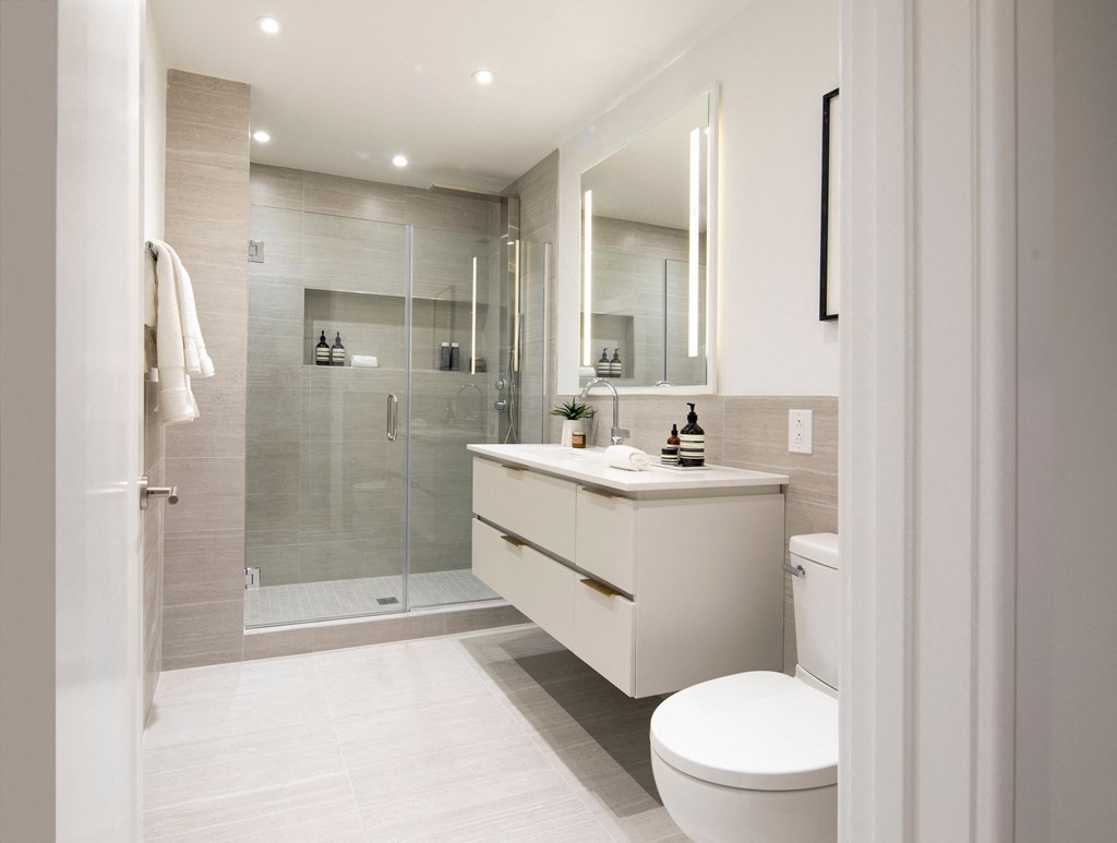 a white bathroom with a shower and a toilet