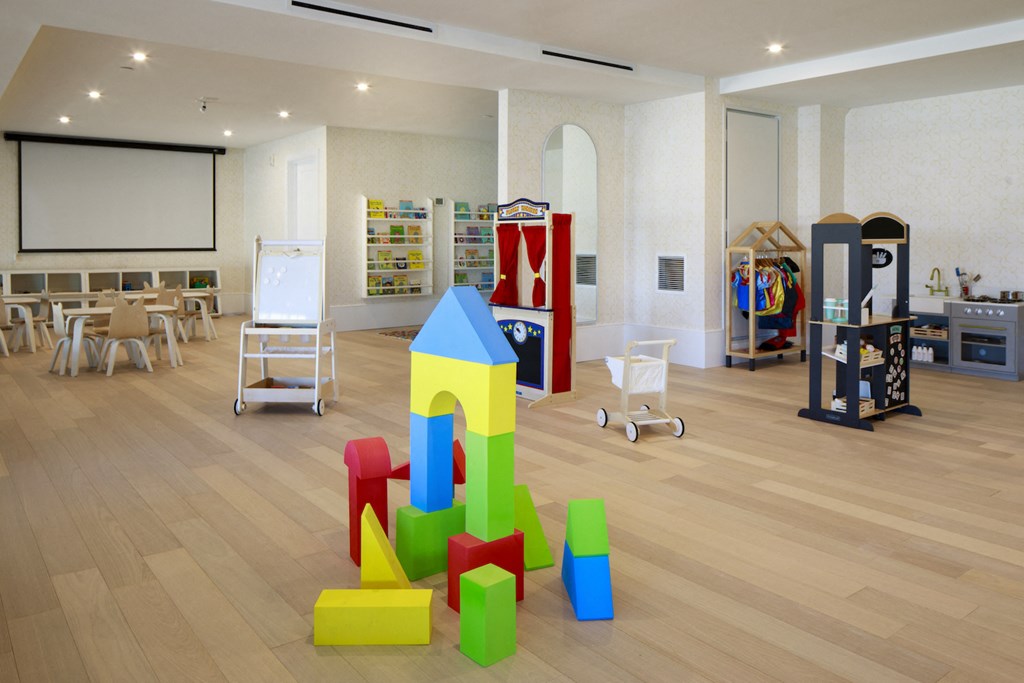 a childrens play room with blocks and chairs on the floor