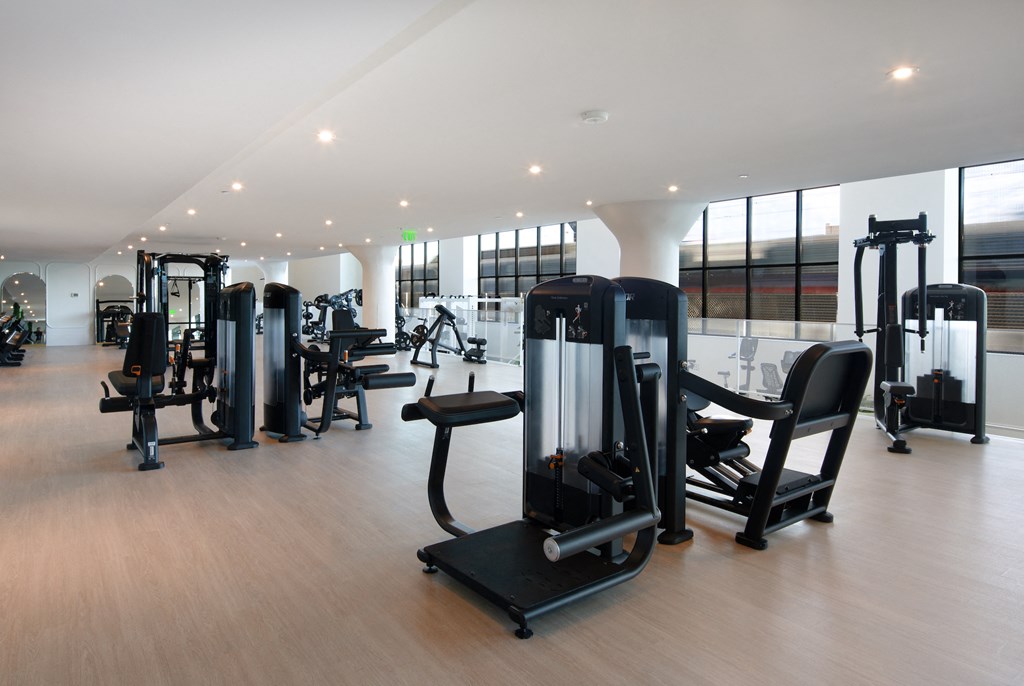 a gym with various exercise equipment on a wooden floor