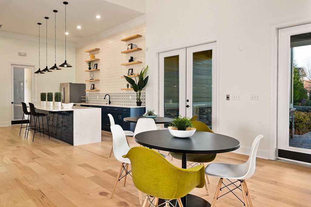 a kitchen and dining room with yellow chairs and a black table