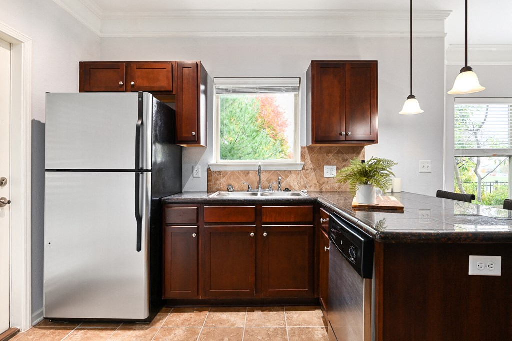 a kitchen with a refrigerator and a sink and a window