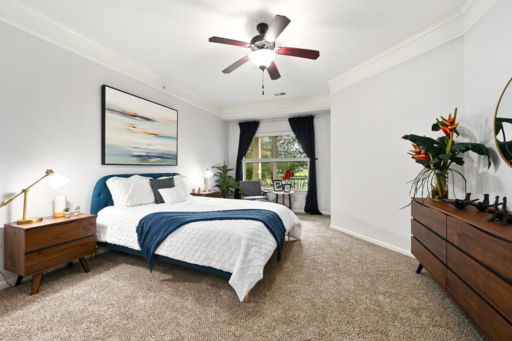 a bedroom with a bed and a ceiling fan