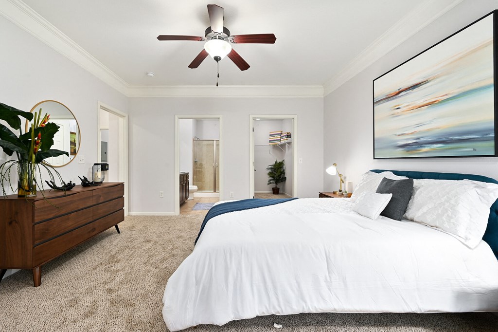 a bedroom with a large bed and a ceiling fan