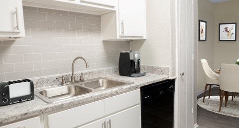 a kitchen with a sink and a coffee maker on the counter