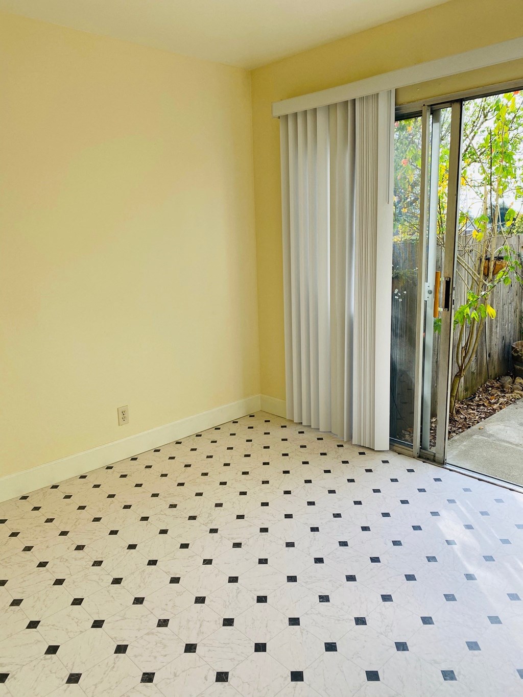 an empty living room with a sliding glass door to a patio