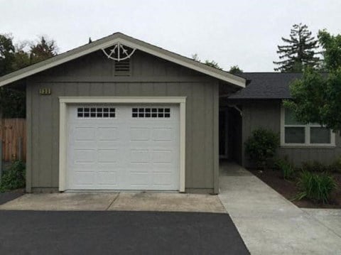 a garage with a white door in front of a house