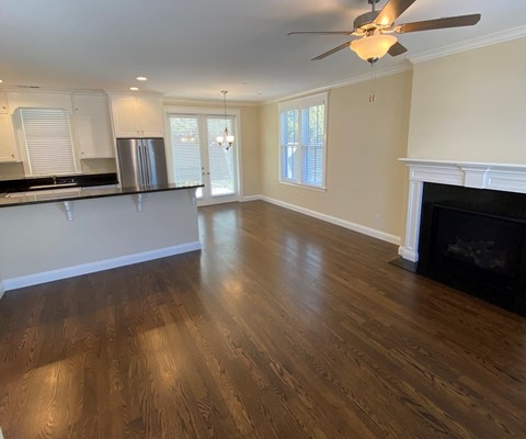 A living room with a fireplace and wood flooring.