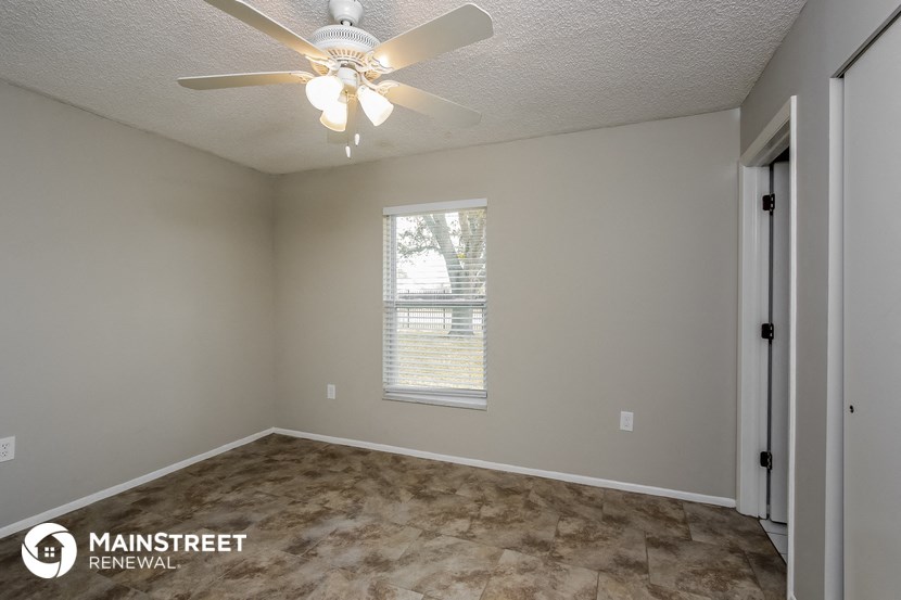 a bedroom with a ceiling fan and a window