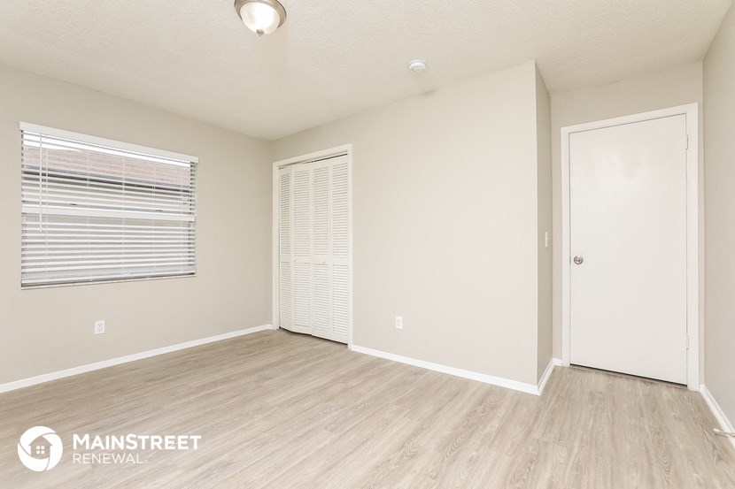 an empty living room with a window and a door