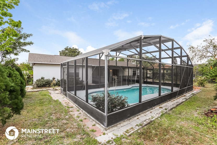a glass house with a pool in a backyard