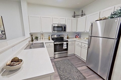 a kitchen with stainless steel appliances and white cabinets