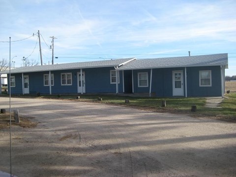 a blue house with a road in front of it