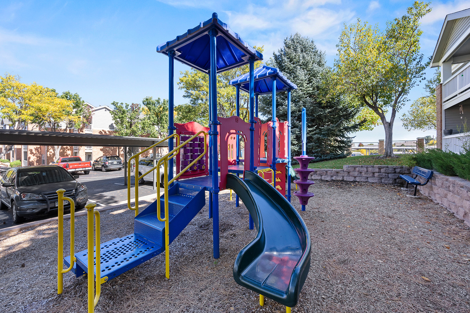 A playground with a blue slide and a red slide.