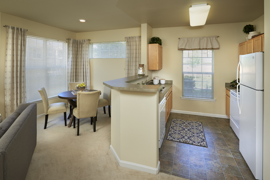 A kitchen with a table and chairs in front of a window.