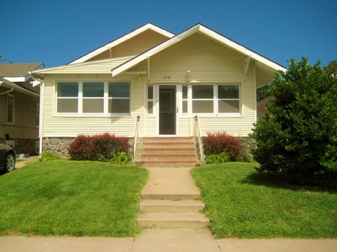 a yellow house with stairs in front of it