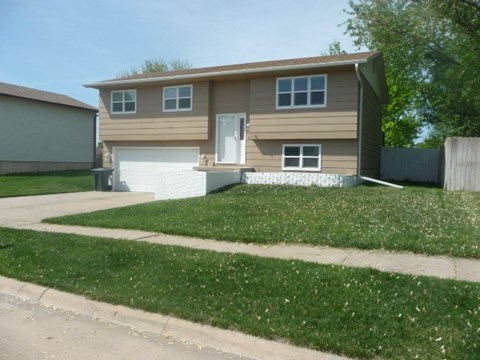 a brown house with a lawn in front of it