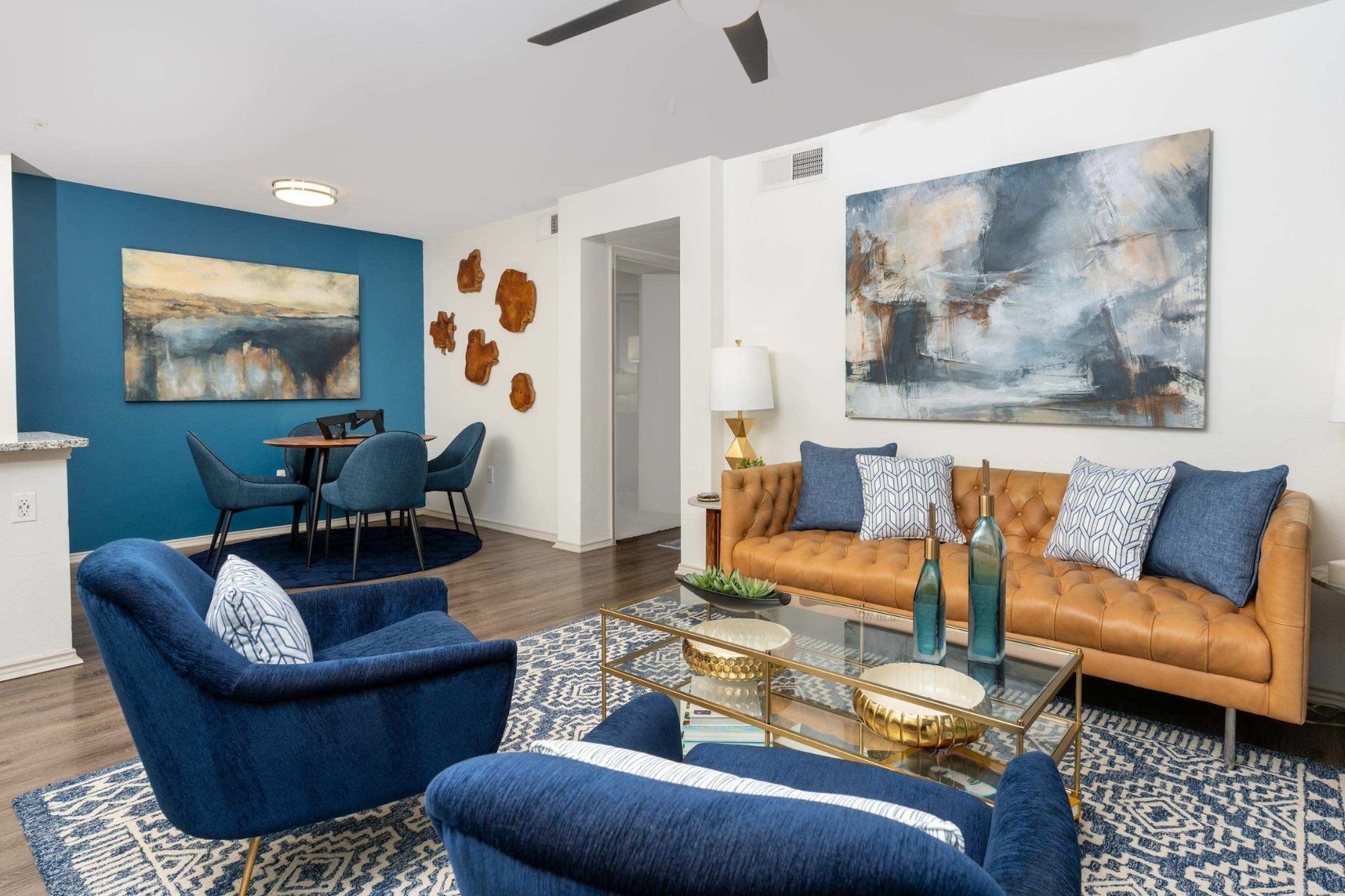 A living room with blue chairs and a brown couch.