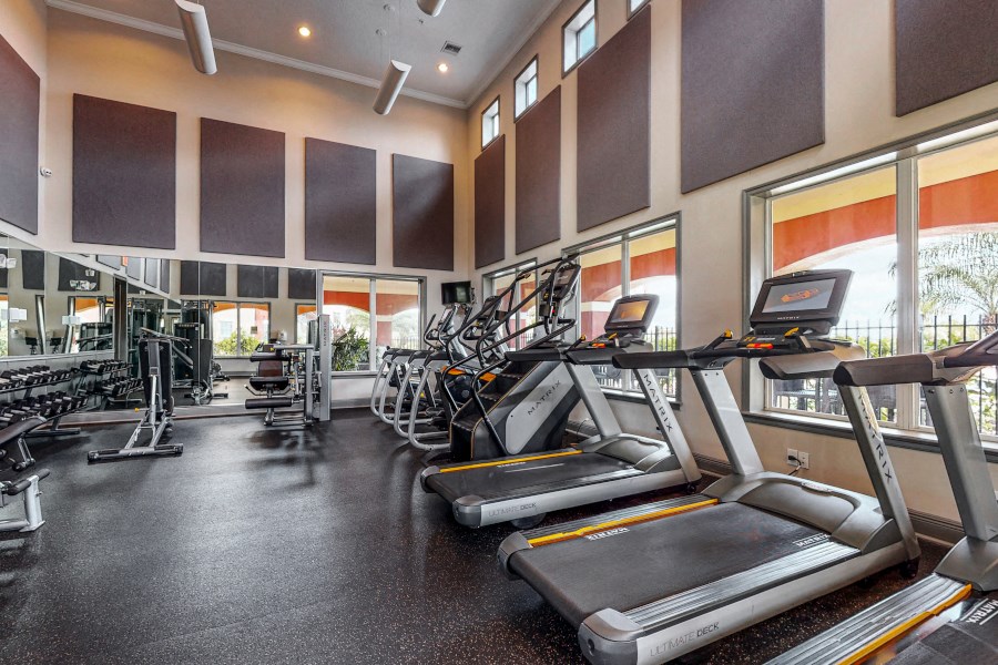 a gym with cardio equipment and windows at the estates apartments
