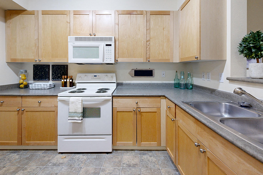 A kitchen with wooden cabinets and a white oven.