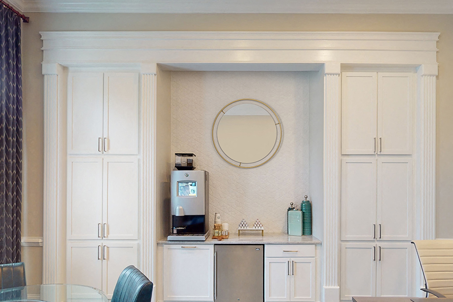 a kitchen with white cabinets and a sink and a mirror
