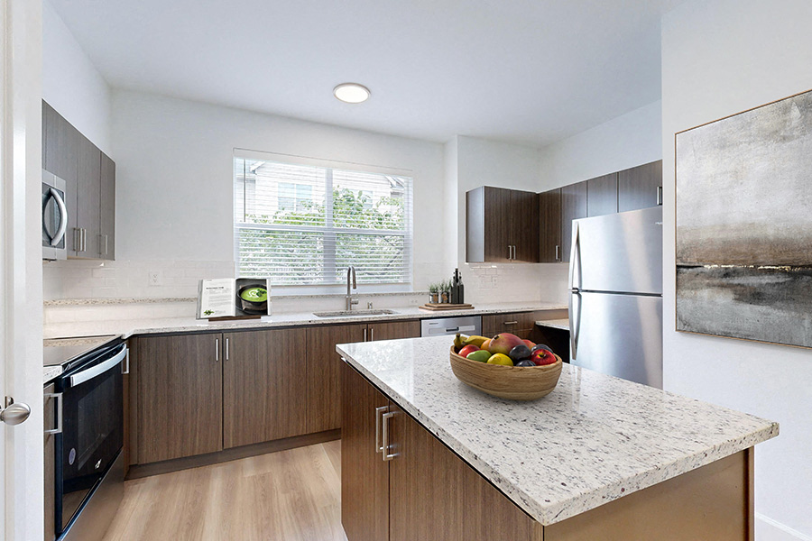 a kitchen with stainless steel appliances and a marble counter top