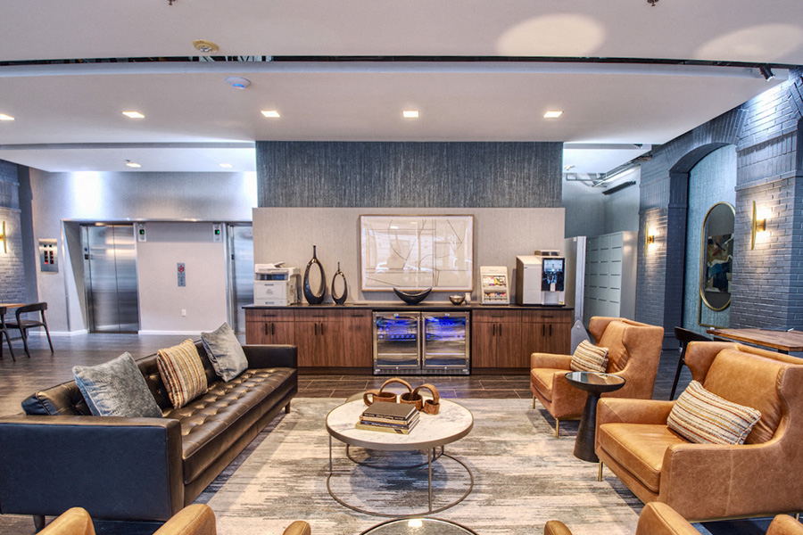 a living room with couches and chairs and a kitchen