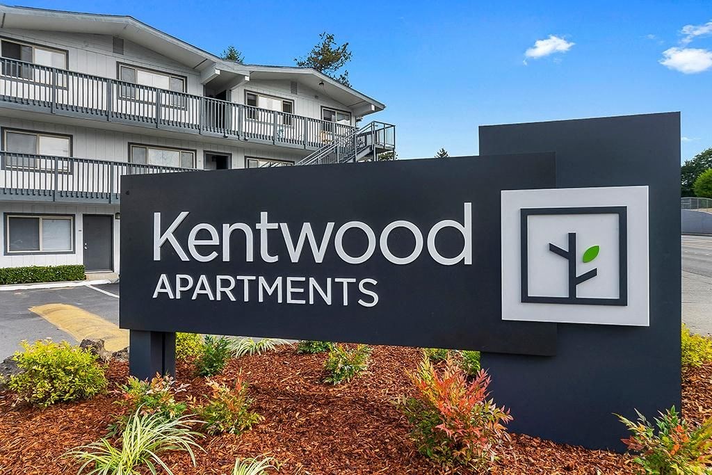a sign for kentwood apartments in front of a building