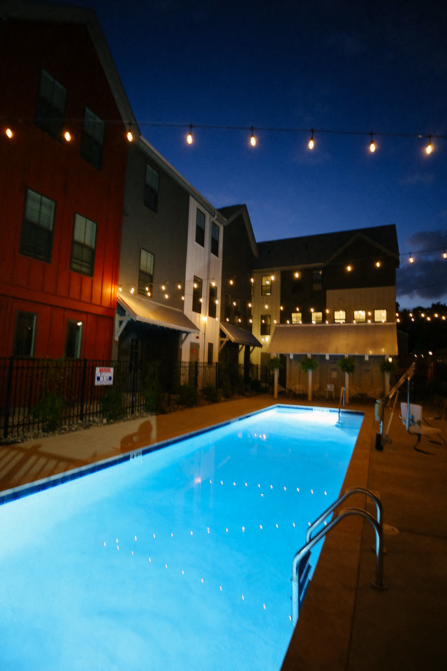 the pool is lit up at night at the holiday inn
