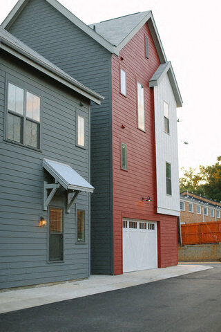 a red and blue house with a white garage door