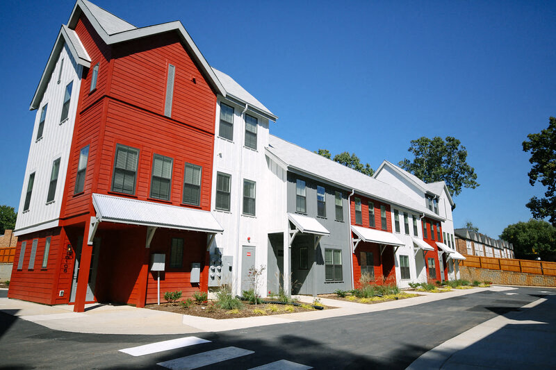 a row of red and white houses on the side of a street