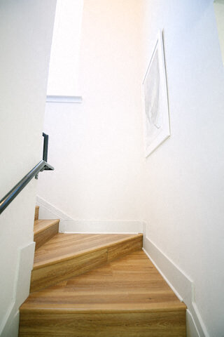 a stairwell with wooden stairs and a picture on the wall