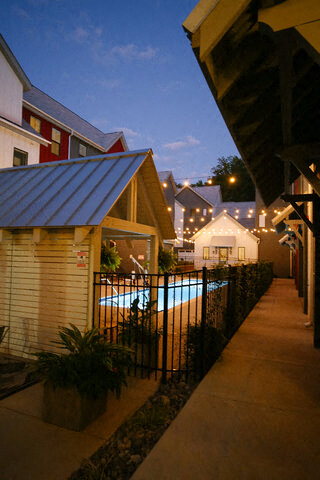a row of houses with a pool and lights