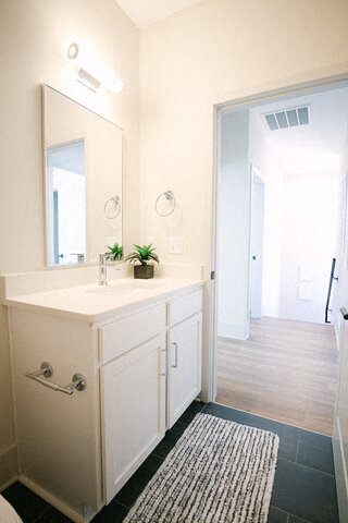 a white bathroom with a sink and a mirror