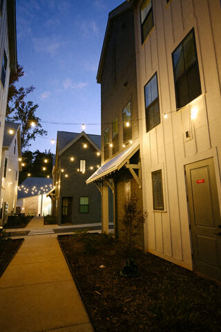 a sidewalk in front of a building at night