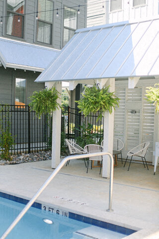a swimming pool and a patio with a table and chairs