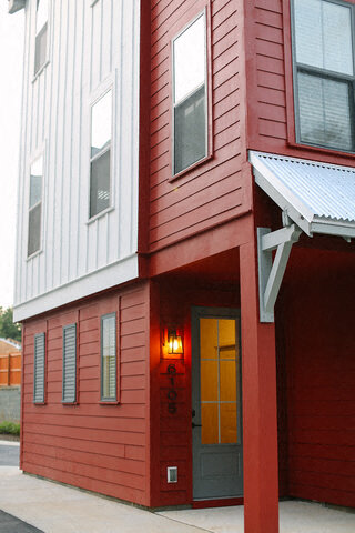 a red and white house with a light on the door