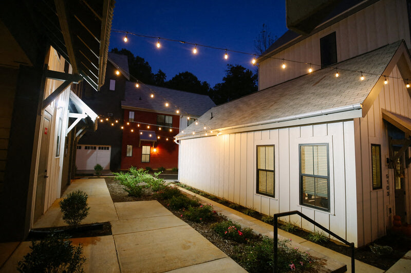 the courtyard is lit up with string lights at night