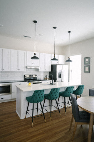 a kitchen with white cabinets and a table with chairs