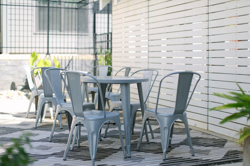 a group of white tables and chairs next to a white house