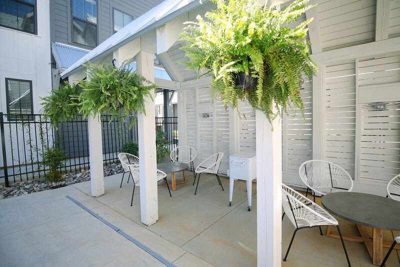 a patio with tables and chairs in front of a building