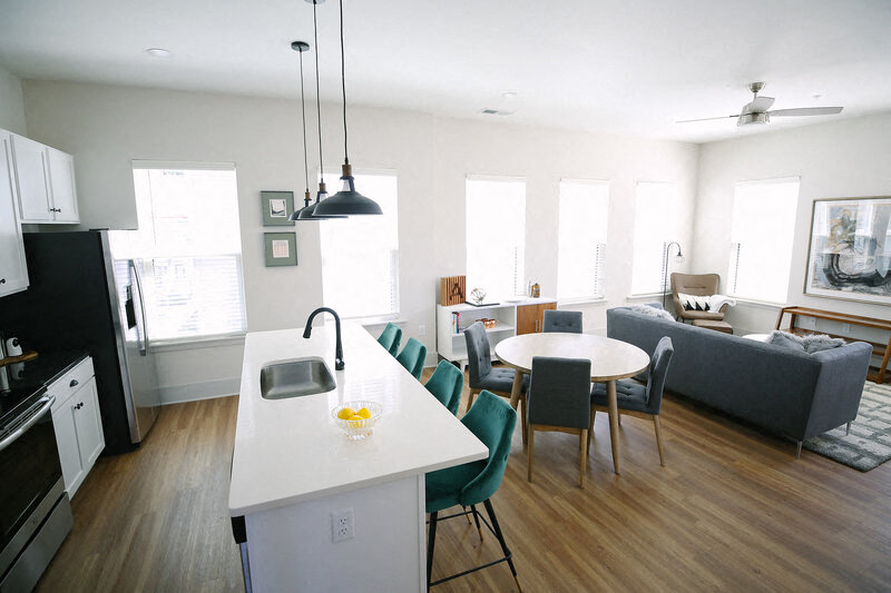 a kitchen and living room with a table and chairs