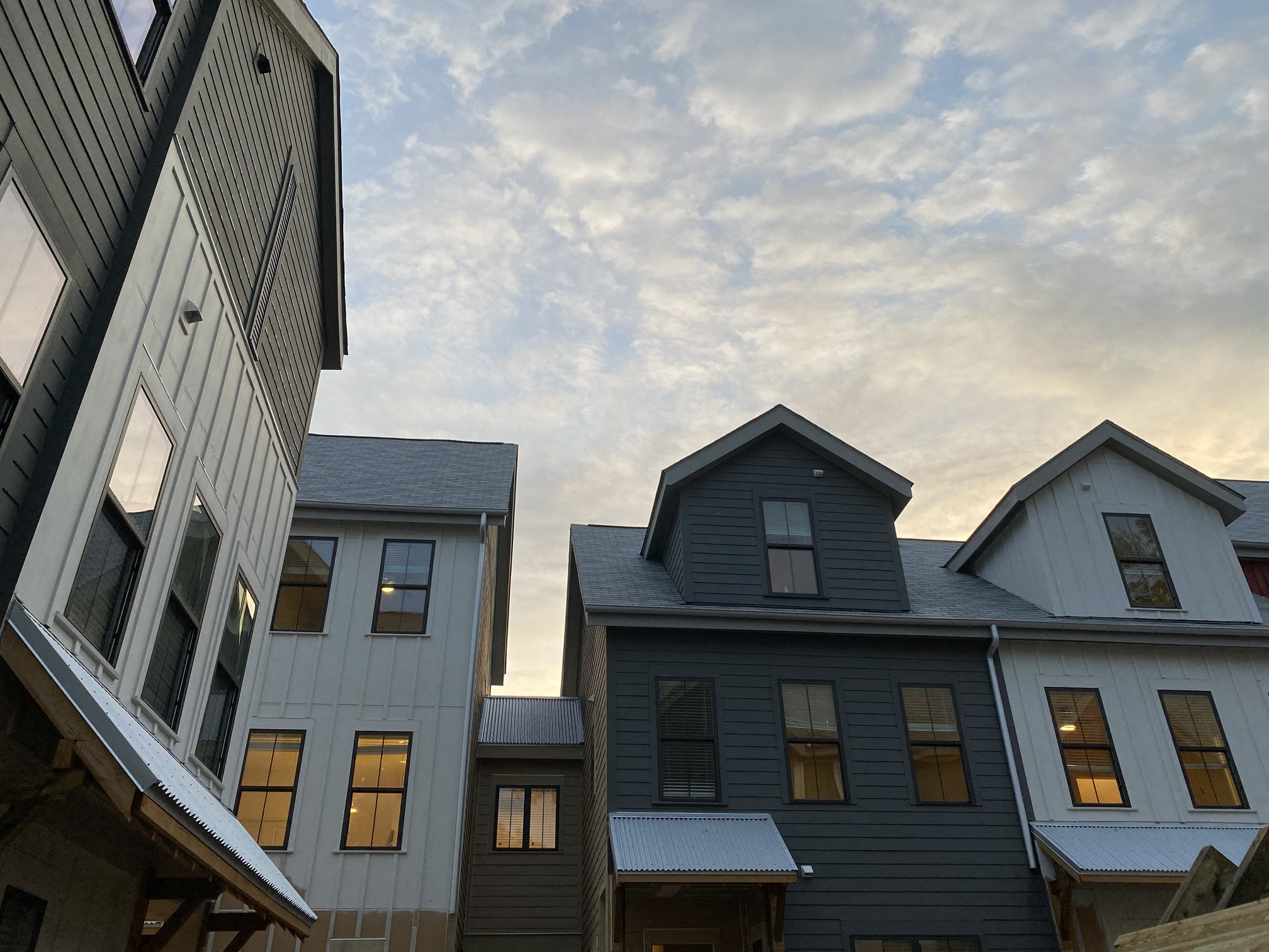 a view of three buildings with the sky in the background