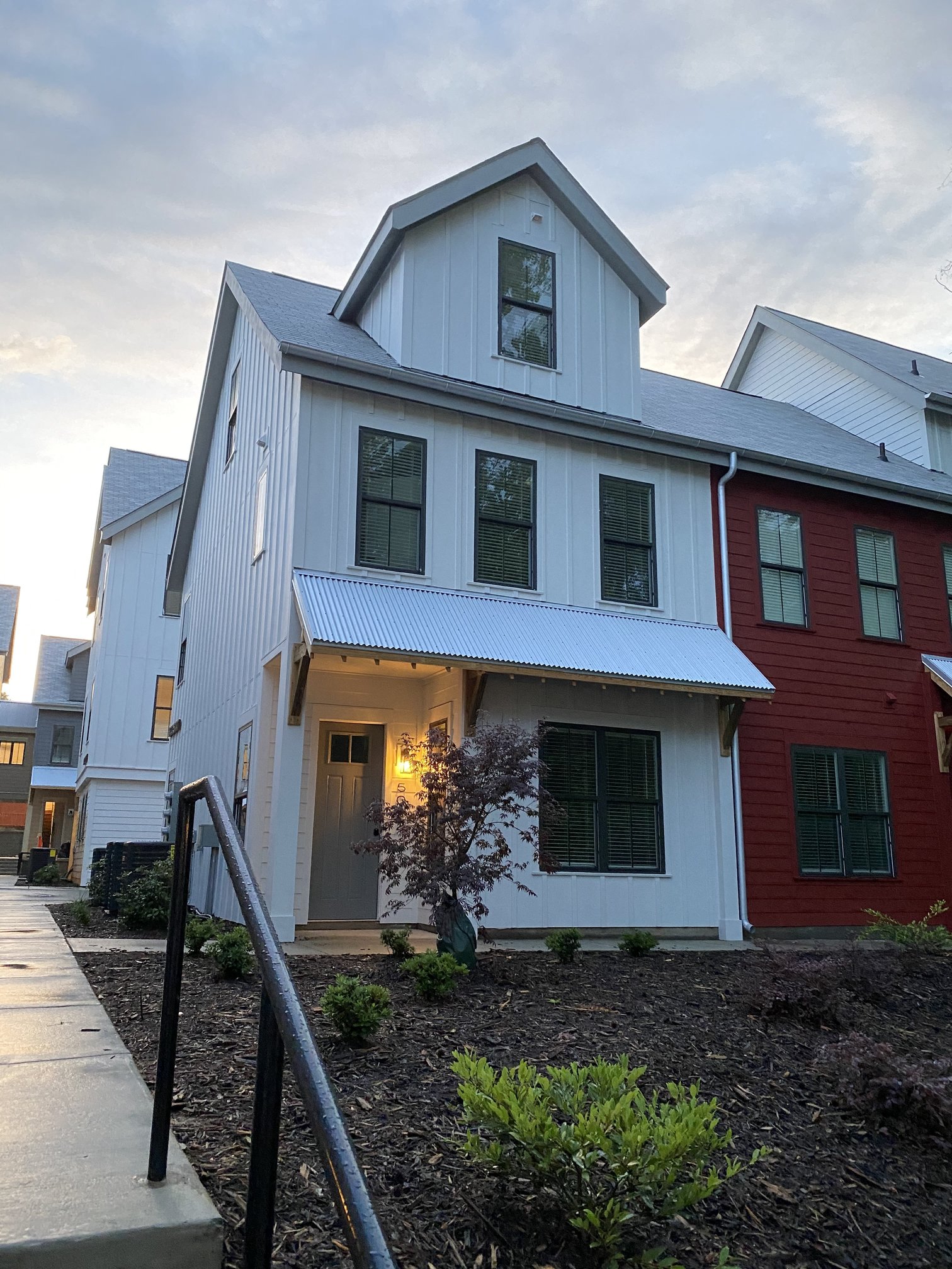 a white and with a sidewalk in front of it