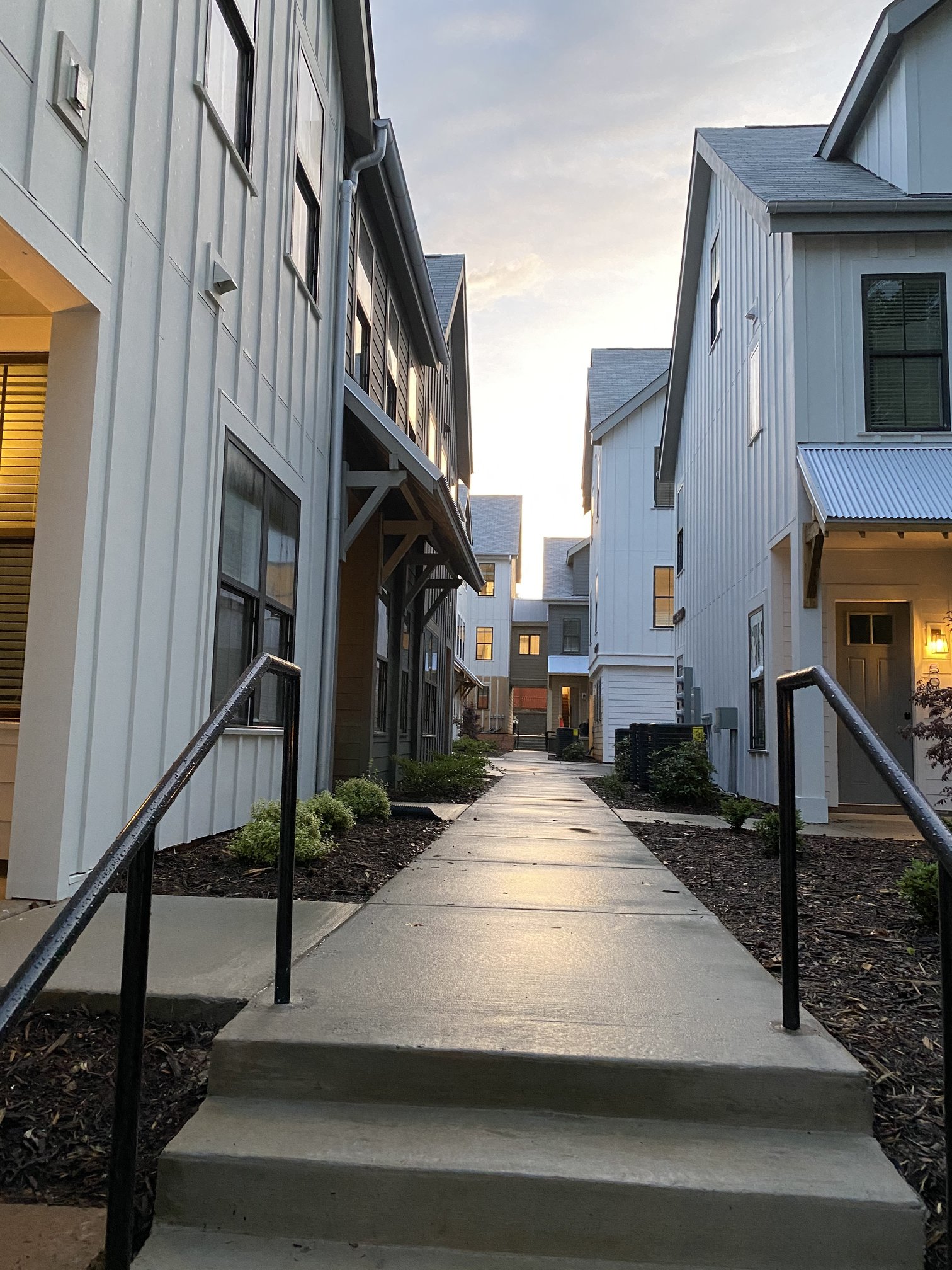 a view of a sidewalk between two buildings