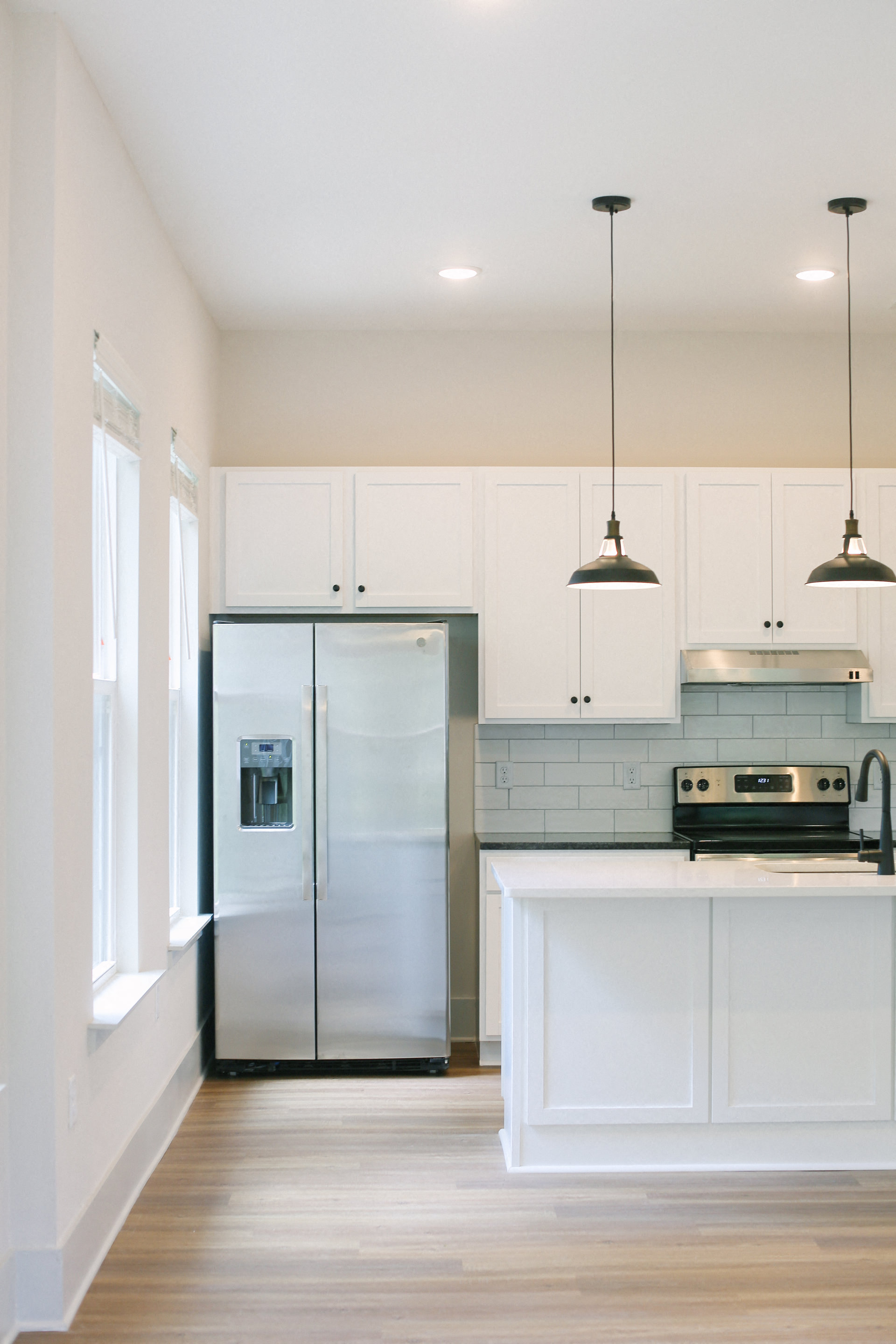 a kitchen with white cabinets and a stainless steel refrigerator