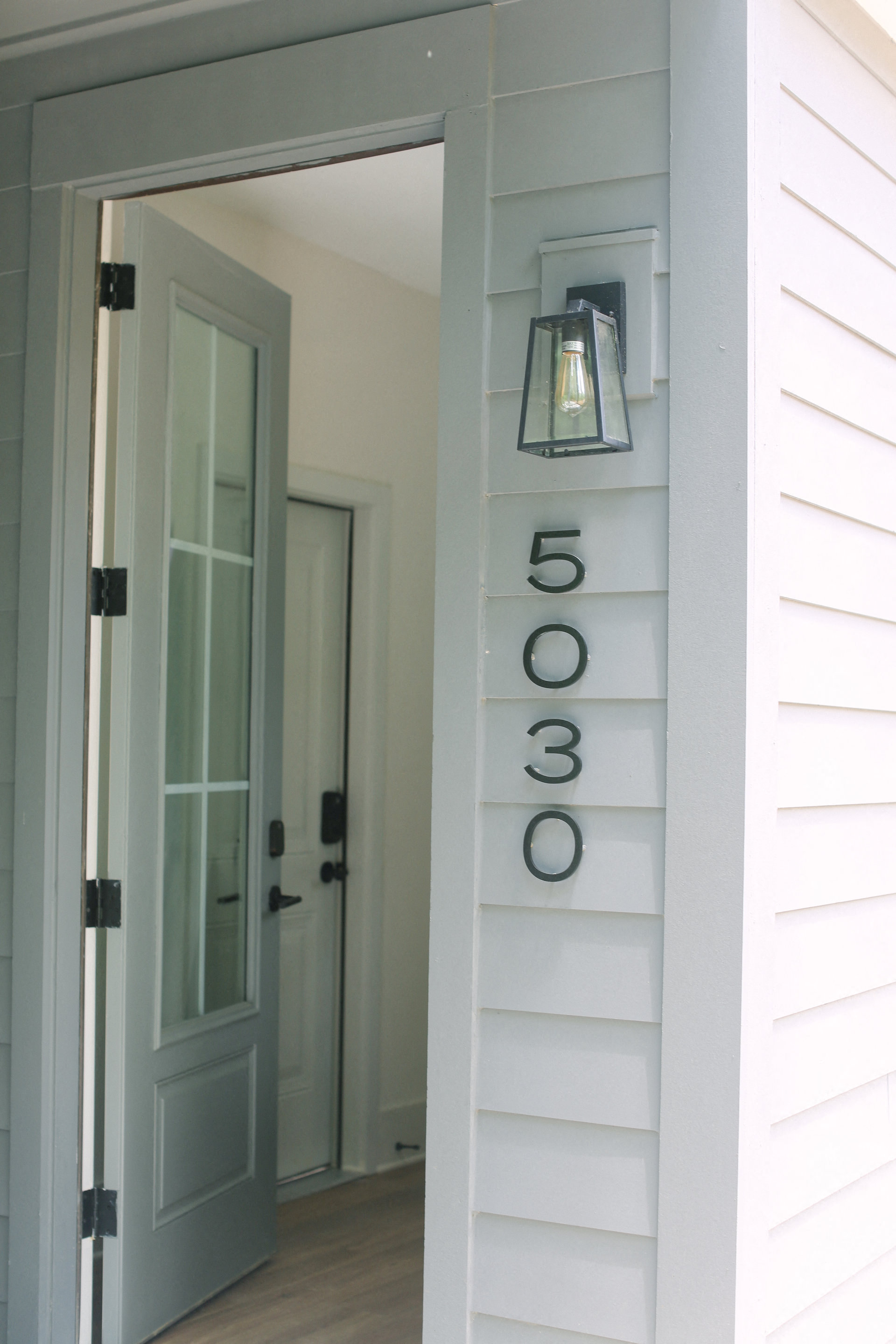 a white house with a blue door and a sign that says 5300